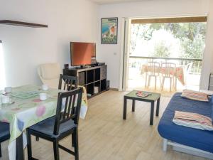 a living room with a table and a tv at Apartment Hameau de Provence by Interhome in Bandol