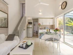 eine Küche und ein Wohnzimmer mit einer Couch und einem Tisch in der Unterkunft Holiday Home Les Oliviers by Interhome in Talmont