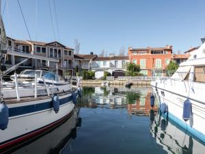 un barco está atracado en un puerto deportivo con casas en Apartment Grand Bassin by Interhome, en Grimaud