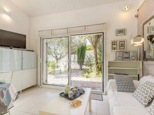 ein Wohnzimmer mit einer weißen Couch und einem großen Fenster in der Unterkunft Holiday Home Les Oliviers by Interhome in Talmont