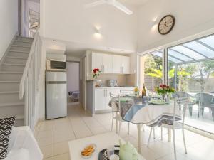 eine Küche und ein Esszimmer mit einem Tisch und einer Uhr in der Unterkunft Holiday Home Les Oliviers by Interhome in Talmont