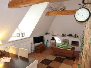 a living room with a table and a clock on the wall at Apartment Odin-2 by Interhome in Galmsbüll