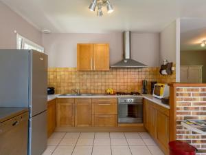 プルエスカにあるHoliday Home Ker Jean - PLC244 by Interhomeのキッチン(木製キャビネット、ステンレス製の冷蔵庫付)