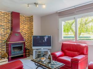 a living room with a red couch and a fireplace at Holiday Home Ker Jean by Interhome in Plouescat