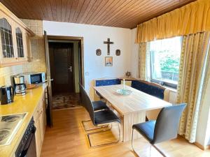 阿爾拉赫的住宿－Apartment Drexler by Interhome，厨房配有桌椅,墙上有十字架