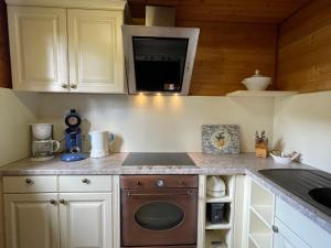 a small kitchen with a stove and a microwave at Holiday Home Alpenblick by Interhome in Pfrungen