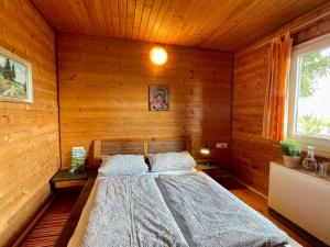 a bedroom with a bed in a wooden cabin at Holiday Home Alpenblick by Interhome in Pfrungen
