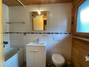 a bathroom with a sink and a toilet and a tub at Holiday Home Alpenblick by Interhome in Pfrungen