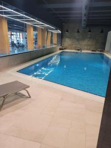 a large swimming pool with blue water in a building at Résidence 5 étoiles 1+1 avec piscine in Istanbul
