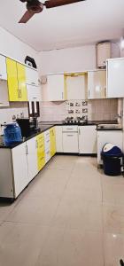 a large kitchen with white cabinets and yellow cabinets at Amazing ! 4 BHK Service Apartment . in New Delhi