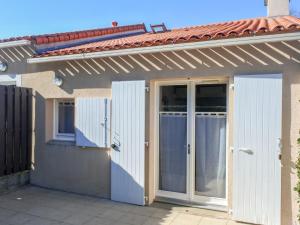una casa con puertas y techo rojo en Holiday Home Rivages d'Olonne by Interhome, en La Pironnière
