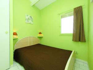 a bedroom with a bed with green walls and a window at Apartment Port Saint Michel by Interhome in Cap d'Agde