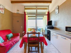 a living room with a red couch and a table at Apartment Port Saint Michel by Interhome in Cap d'Agde