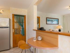 kuchnia z blatem, stołem i lodówką w obiekcie Holiday Home L'Hermine - PLC228 by Interhome w mieście Plouescat