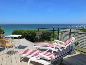 eine Terrasse mit Stühlen, einem Tisch und Meerblick in der Unterkunft Holiday Home La Villa Marine - PLC225 by Interhome in Plouescat