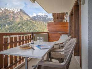 uma mesa branca e cadeiras numa varanda com montanhas em Apartment Domino B 48 by Interhome em Ovronnaz
