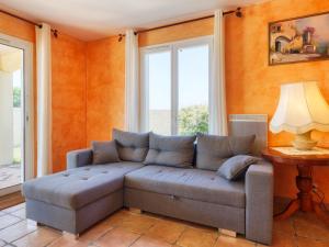 een woonkamer met een bank en een raam bij Holiday Home Les Lavandiers - ORD100 by Interhome in Ordonnac