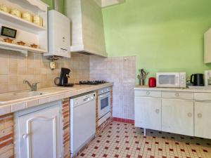 cocina con armarios blancos y microondas en Holiday Home La Côte d'Argent - MVT175 by Interhome, en Montalivet-les-Bains