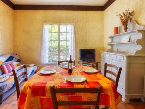 comedor con mesa con sillas y TV en Holiday Home La Côte d'Argent - MVT175 by Interhome, en Montalivet-les-Bains