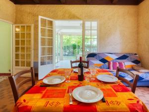 una mesa de comedor con una botella de vino. en Holiday Home La Côte d'Argent - MVT175 by Interhome, en Montalivet-les-Bains