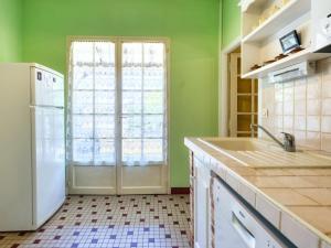 eine Küche mit grünen Wänden und einem weißen Kühlschrank in der Unterkunft Holiday Home La Côte d'Argent by Interhome in Montalivet-les-Bains + 17 Fotos