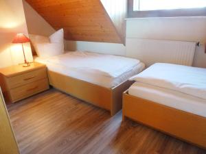 una piccola camera con due letti e un comodino di Apartment Schwarzwaldblick-8 by Interhome a Schonach