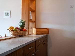 una barra de cocina con una cesta de fruta. en Apartment Christiania I G8 by Interhome en Nendaz