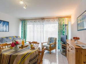 a living room with a table and a television at Apartment Ty Bugale by Interhome in Concarneau