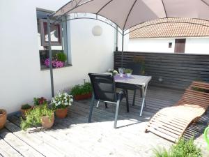 eine Terrasse mit einem Tisch, Stühlen und einem Sonnenschirm in der Unterkunft Holiday Home Albergo Centro by Interhome in Hüfingen