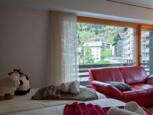 Una sala de estar con un sofá rojo y una gran ventana. en Apartment Diana E2 by Interhome, en Nendaz 23 fotos más