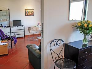 een woonkamer met een bank en een tafel met een vaas met bloemen bij Apartment Cleopatra by Interhome in Montagnola