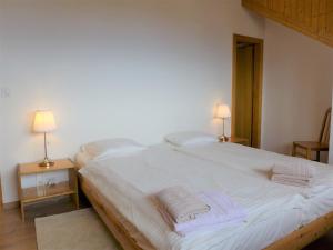 a bedroom with a large white bed with towels on it at Apartment Victoria C 8 by Interhome in Crans-Montana