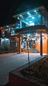 um edifício com uma árvore em frente à noite em Kamals Lodge em Skardu