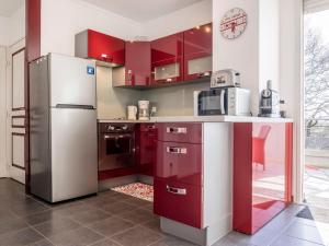 a kitchen with red cabinets and a refrigerator at Apartment Résidence Baigura-1 by Interhome in Saint-Jean-de-Luz