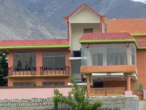 a house with a mountain in the background at Kamals Lodge in Skardu