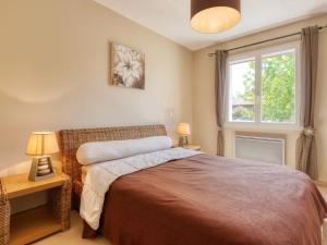 ein Schlafzimmer mit einem Bett mit zwei Lampen und einem Fenster in der Unterkunft Holiday Home Les Ormes by Interhome in Montalivet-les-Bains