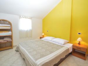 a bedroom with a large bed with yellow walls at Apartment Fabiana - PUL615 by Interhome in Valdebek