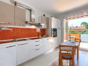kuchnia z białymi szafkami i stołem oraz jadalnia w obiekcie Apartment Villa Alba-1 by Interhome w mieście Umag