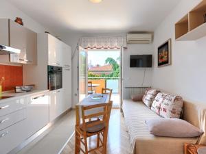 kuchnia i salon z kanapą i stołem w obiekcie Apartment Villa Alba-1 by Interhome w mieście Umag