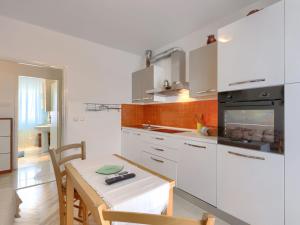 kuchnia z białymi szafkami, stołem i stołem oraz tableablish w obiekcie Apartment Villa Alba-1 by Interhome w mieście Umag +14 zdjęć