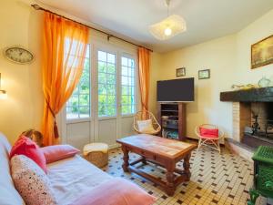 ein Wohnzimmer mit einem Sofa und einem TV in der Unterkunft Holiday Home La Bruyère - MVT220 by Interhome in Montalivet-les-Bains