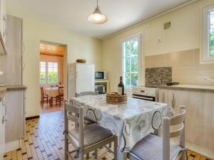 eine Küche mit einem Tisch mit Stühlen und einem Kühlschrank in der Unterkunft Holiday Home La Bruyère - MVT220 by Interhome in Montalivet-les-Bains