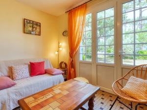 ein Wohnzimmer mit einem Sofa und einem Tisch in der Unterkunft Holiday Home La Bruyère - MVT220 by Interhome in Montalivet-les-Bains