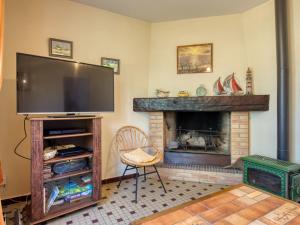 ein Wohnzimmer mit einem TV und einem Kamin in der Unterkunft Holiday Home La Bruyère - MVT220 by Interhome in Montalivet-les-Bains