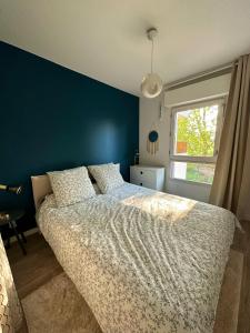 1 dormitorio con 1 cama grande y pared azul en Havre de paix à 15’ Paris et 10’ Stade de France, en Saint-Denis
