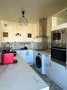 a kitchen with a washing machine and a washer at Havre de paix à 15’ Paris et 10’ Stade de France in Saint-Denis