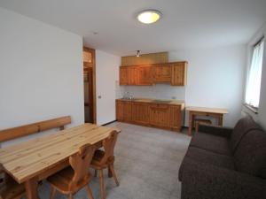 una cucina con tavolo in legno e divano di Apartment Lembondel-3 by Interhome a Tiarno di Sotto