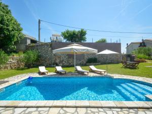 basen z 2 krzesłami i parasolem w obiekcie Holiday Home Laura by Interhome w Puli