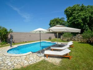 una piscina con sombrilla y tumbonas en Holiday Home Laura - PUL470 by Interhome, en Pula