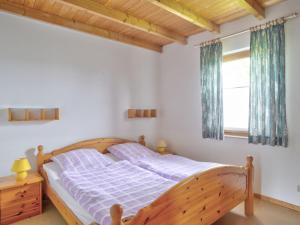 ein Schlafzimmer mit einem Holzbett und einem Fenster in der Unterkunft Holiday Home Feriendorf Uslar-1 by Interhome in Uslar